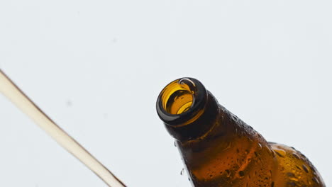 Cider-splashing-misted-flask-closeup.-Cold-lager-beverage-foaming-fountaining