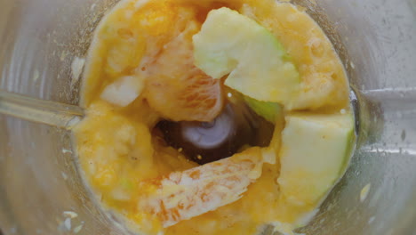 Closeup-preparing-fruit-puree-in-blender-top-view.-Ingredients-blending-in-mixer