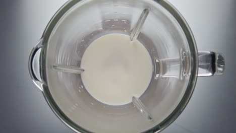 Fresh-white-milk-blending-in-mixer-super-slow-motion-closeup.-Dairy-product.