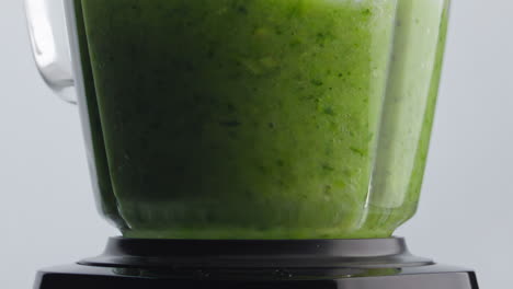 Green-smoothie-blend-mixing-inside-blender-bowl-in-super-slow-motion-close-up.