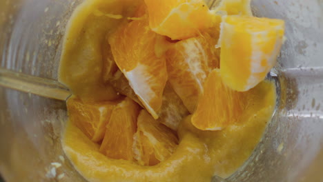 Orange-falling-blended-smoothie-in-mixer-close-up.-Citrus-dropped-in-blender.