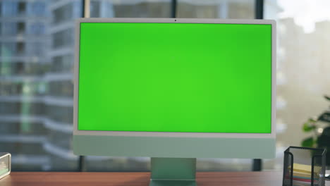 Green-screen-template-monitor-at-workplace-closeup.-Mockup-pc-computer-interior