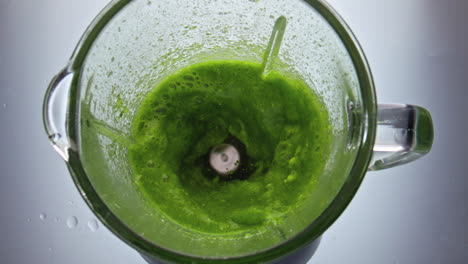 Green-veggie-blend-mixing-in-blender-close-up-top-view.-Delicious-vitamin-food.