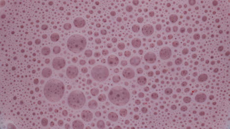 Closeup-berry-smoothie-bubbles-inside-blender.-Top-view-tasty-fruit-cocktail.
