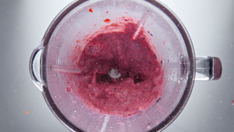 Milk-pouring-blending-berries-closeup-top-view.-Strawberry-blueberry-mixing.