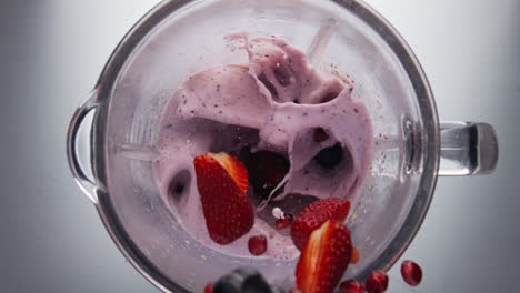 Adding-berries-blending-smoothie-in-super-slow-motion-closeup.-Natural-milkshake