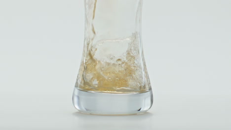 Frisches-Goldenes-Bier-Fließt-Auf-Glas-Vor-Weißem-Hintergrund,-Nahaufnahme.-Weizenmalzgetränk