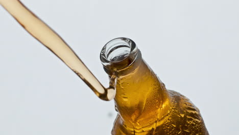 Opening-glass-ipa-bottle-closeup.-Unfiltered-beer-splashing-condensating-flask