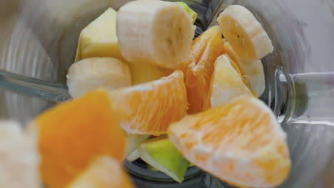 Closeup-adding-fruits-blender-top-view.-Natural-ingredients-for-vitamin-cocktail