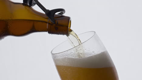 Beer-bottle-filling-goblet-with-lager-craft-drink-in-super-slow-motion-close-up
