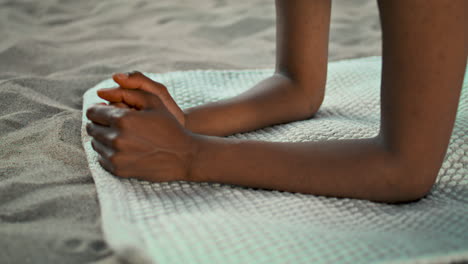 Closeup-girl-hands-yoga-mat-on-sand-seashore.-Unknown-woman-standing-on-elbows.