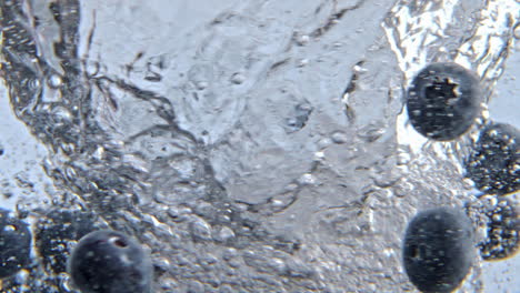 Dark-berries-tossing-whirlpool-water-glassware-closeup.-Detox-liquid-swirling