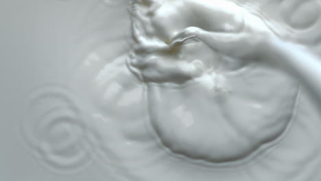 Milk-jet-pouring-slowly-top-view.-Stream-splashing-liquid-filling-container
