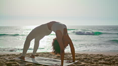 Frau-Praktiziert-Urdhva-Dhanurasana-Am-Sandstrand-Bei-Sonnenaufgang.-Mädchen-Trainiert-Yoga