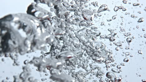 Red-fruits-immersed-liquid-bubbles-closeup.-Raw-food-making-splashes-water-glass