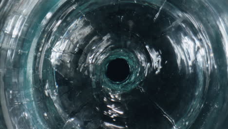 Swirling-drink-rotating-glassware-closeup.-Cool-aqua-spinning-in-glass-goblet