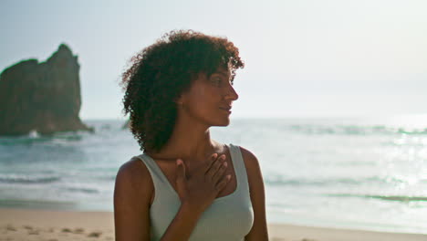 Girl-enjoy-sunrise-meditating-on-beach-closeup.-Serene-woman-standing-seashore