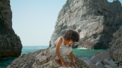 Mädchen-Praktiziert-Yoga-Pose-Am-Ursa-Beach-Vertikal.-Afrikanische-Fitte-Frau-Beugt-Körper