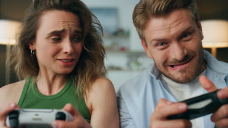 Competitive-pair-holding-gamepads-home-portrait.-Nervous-woman-losing-pov-video