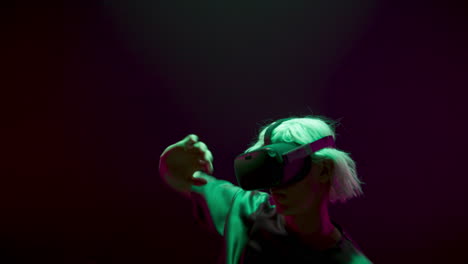 Vr-guy-dancing-headset-in-dark-neon-room.-Energetic-player-experiencing-hi-tech