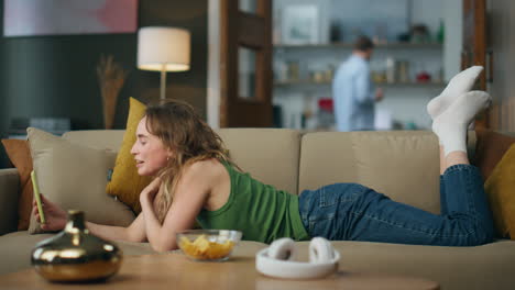 Lazy-girl-video-calling-cellphone-laying-sofa.-Smiling-woman-talking-telephone