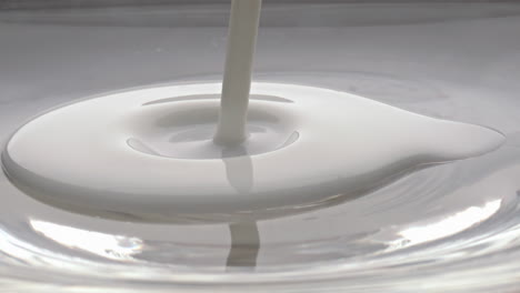 Sauberer-Milchstrahl,-Der-Aus-Einer-Glasschüssel-Gießt,-Nahaufnahme.-Cremiger-Flüssigkeitsstrom-Fließt-Langsam