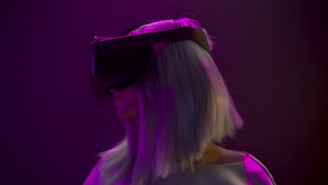 Excited-woman-experiencing-headset-videogame-neon-background.-Technology-concept