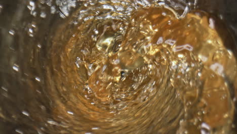 Splashing-hoppy-drink-bubbling-goblet-closeup.-Waving-craft-ale-inside-glass