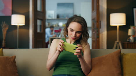 Focused-gamer-playing-mobile-phone-at-home-closeup.-Woman-enjoying-video-games