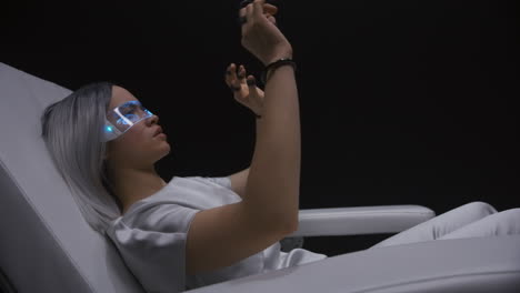 Cyberpunk-woman-enjoying-VR-interactive-chair-closeup.-Player-touching-metaverse