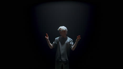 Man-using-virtual-simulation-goggles-in-dark-room.-Futuristic-player-touching