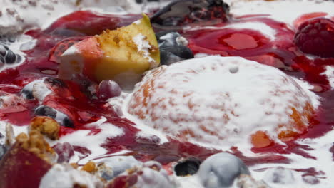 Jam-pouring-fruits-muesli-dipped-into-fresh-yogurt-closeup.-Nutrient-porridge.