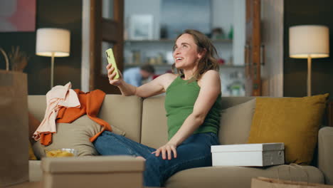 Glückliche-Frau-Mit-Smartphone-Auf-Dem-Sofa.-Überglückliche-Kaufsüchtige,-Die-Sich-Emotional-Freut