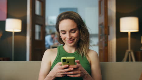 Lächelnde-Frau,-Die-Eine-SMS-Schreibt,-Telefon,-Wohnzimmer,-Zoom-Auf.-Frau,-Die-Mit-Dem-Handy-Chattet