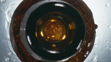 Dark-lager-overflowing-bottle-closeup.-Unfiltered-cool-beverage-splashing-flask