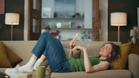 Suffering-lady-crying-alone-laying-sofa-indoors.-Sad-woman-holding-mobile-phone