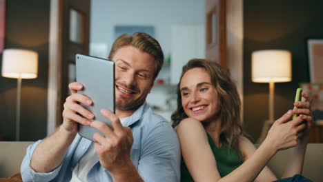 Closeup-relaxed-couple-talking-home-weekend.-Lazy-love-pair-resting-with-gadgets