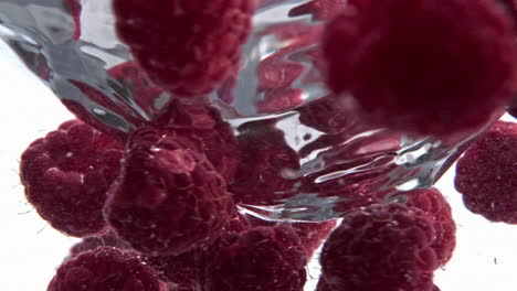 Clear-raspberry-beverage-funnel-inside-glassware-closeup.-Cold-cocktail-spinning