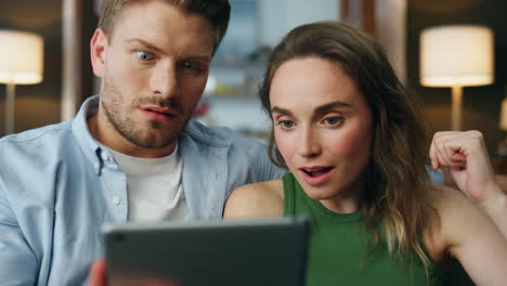 Surprised-pair-staring-tablet-home-zoom-on.-Shocked-spouses-faces-received-bills