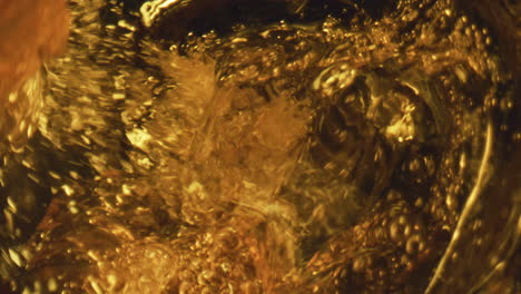 Craft-beer-swirling-splashing-closeup.-Golden-lager-stream-creating-bubbles