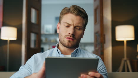 Focused-man-reading-pad-computer-zoom-out.-Serious-businessman-zooming-screen