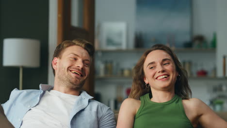 Carefree-spouses-faces-laughing-sitting-sofa-closeup.-Excited-people-having-fun