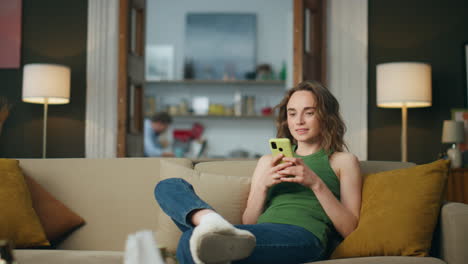 Smiling-girl-chatting-cellphone-at-home.-Positive-lady-browsing-social-media