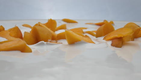 Cremiger-Joghurt-In-Scheiben-Geschnitten-Aprikosen-Hintergrund-Nahaufnahme.-Obst-Liegt-In-Milch-Dessert