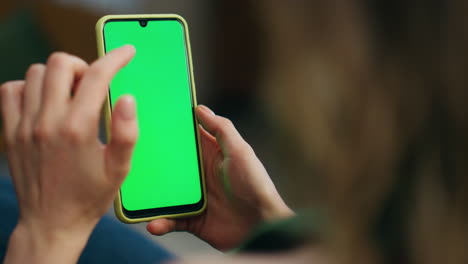 Woman-hand-swiping-green-phone-screen-closeup.-Unknown-relaxed-girl-scrolling