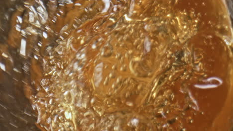 Goldener-Ale-Jet-In-Glaswaren,-Nahaufnahme.-Gerstenflüssigkeit-Spritzt-In-Glas