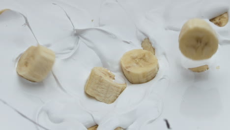 Sweet-banana-falling-yogurt-making-splashes-in-super-slow-motion-close-up.