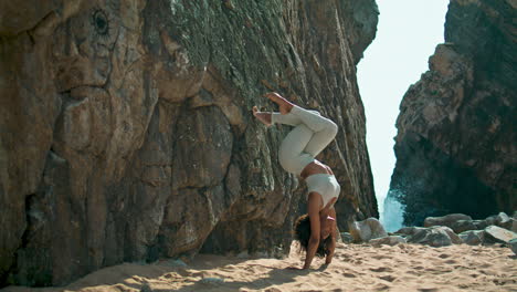 Yogi-Mädchen-Steht-Kopfüber-Auf-Dem-Felsigen-Sandstrand-Von-Ursa.-Frau-Macht-Yoga-Asana