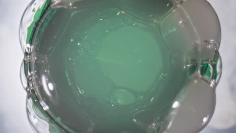 Frozen-block-splashing-bottle-closeup.-Tasty-ipa-foaming-from-flask-slow-motion