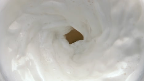 Lactose-beverage-swirling-moving-top-view.-Milk-rotating-with-waves-closeup